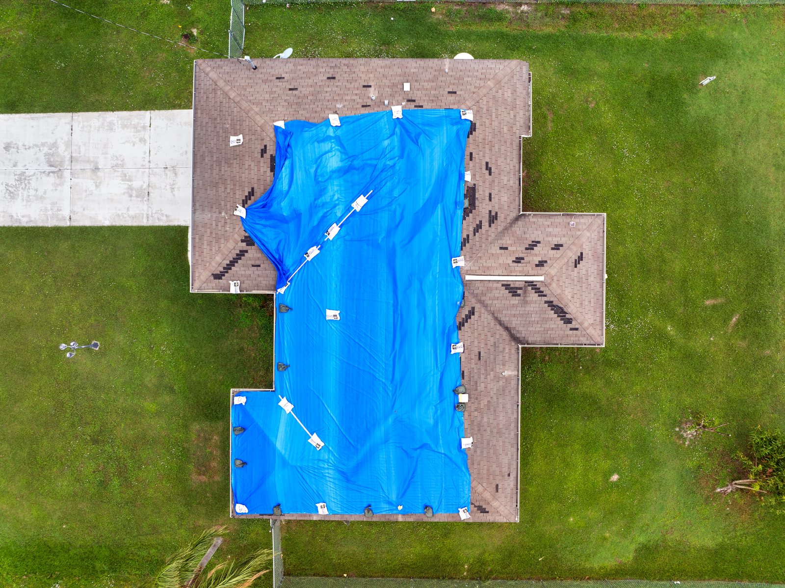 Aerial view of an emergency blue tarp on a hail-damaged Colorado Springs roof by Fixins on a Colorado Springs roof
